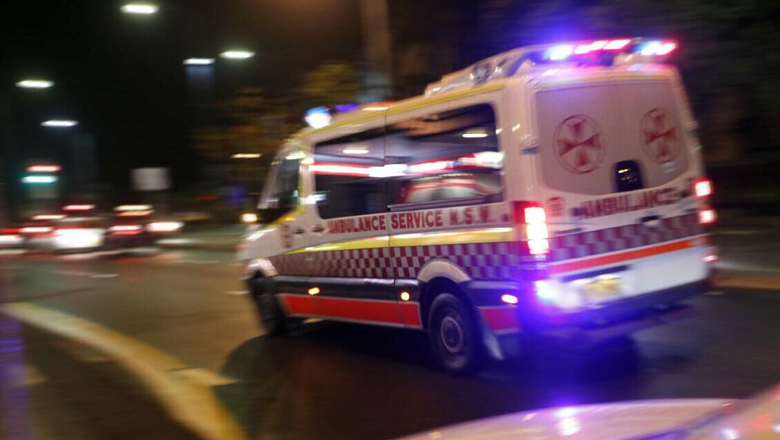 A file picture of an ambulance on the road at night with flashing lights. 