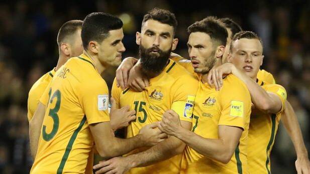  Socceroo Mile Jedinak is congratulated by teammates after his penalty.  Photo: Robert Cianflone 