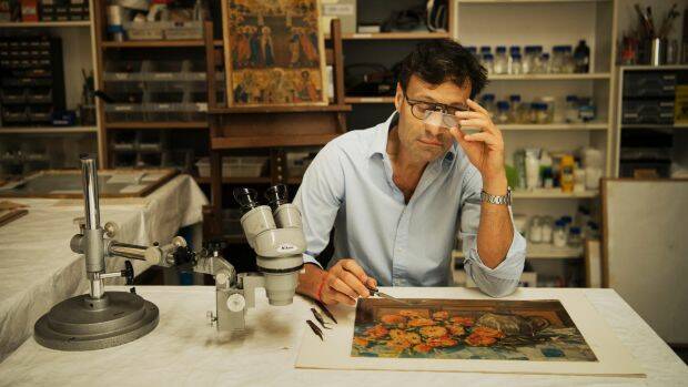 David Stein is restoring the painting by renowned Australian artist Margaret Olley. Photo: Louise Kennerley
