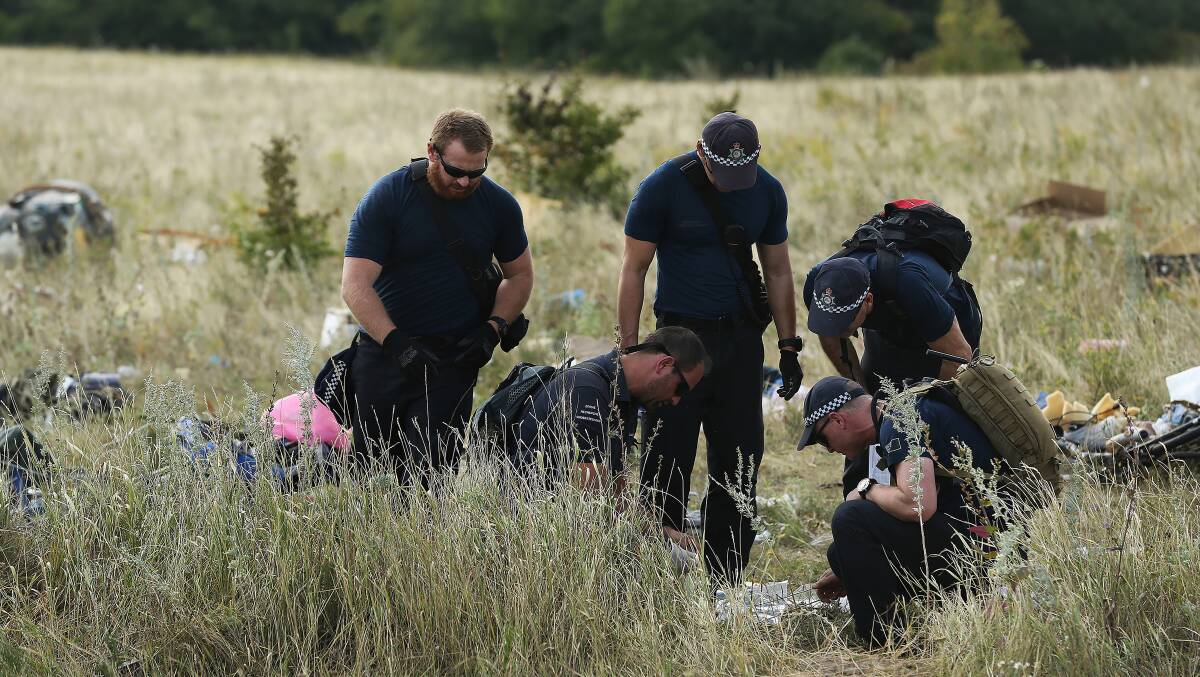AFP officers and their Dutch counterparts collect human remains from the MH-17 crash site. Photo: Kate Geraghty