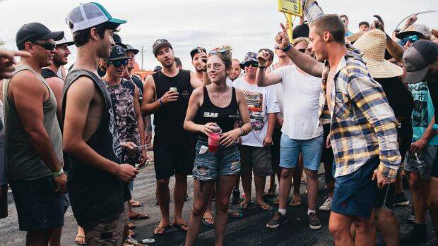 A group of men surround a young woman and shout 'black top, black top' requesting she remove her top. She didn't remove her top. Photo: Rohan Thomson
