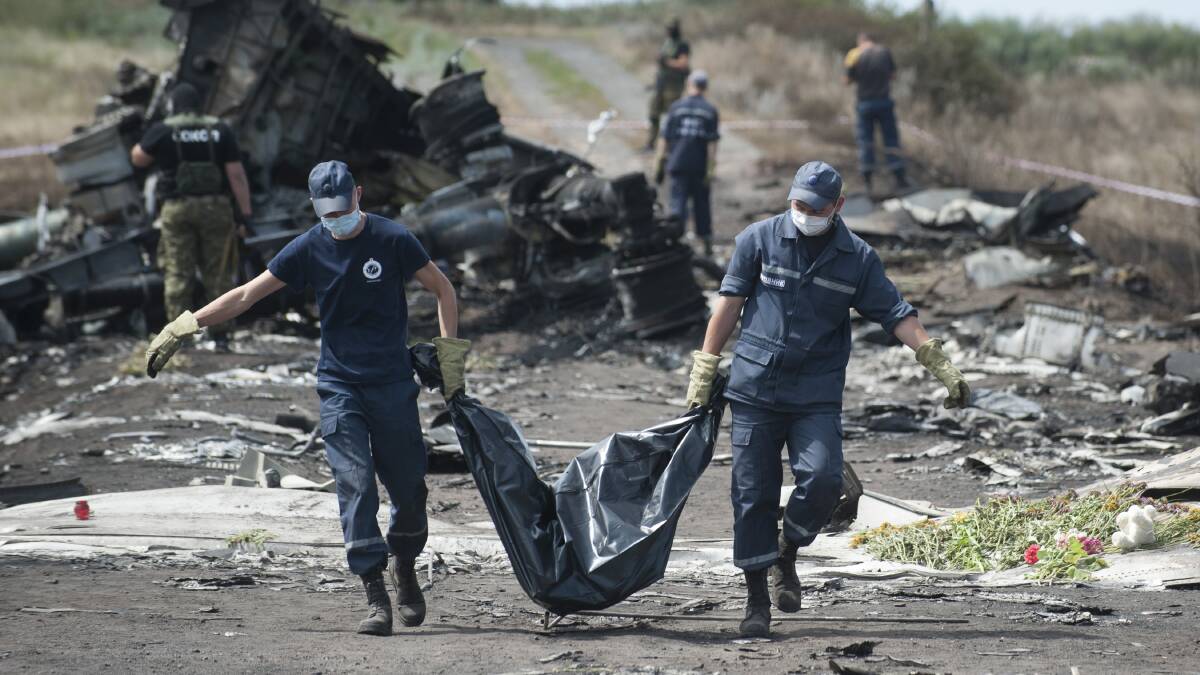 Emergency workers recover victims from the crash site of flight MH-17 in Ukraine last year. Picture: Evgeniy Maloletka