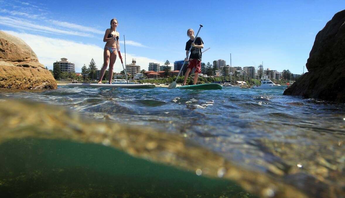 Good times: Smiths Hill students Josh Moygannon and Leah Harvey enjoy the sunny conditions on stand-up paddleboards at Belmore Basin on Thursday. Picture: SYLVIA LIBER