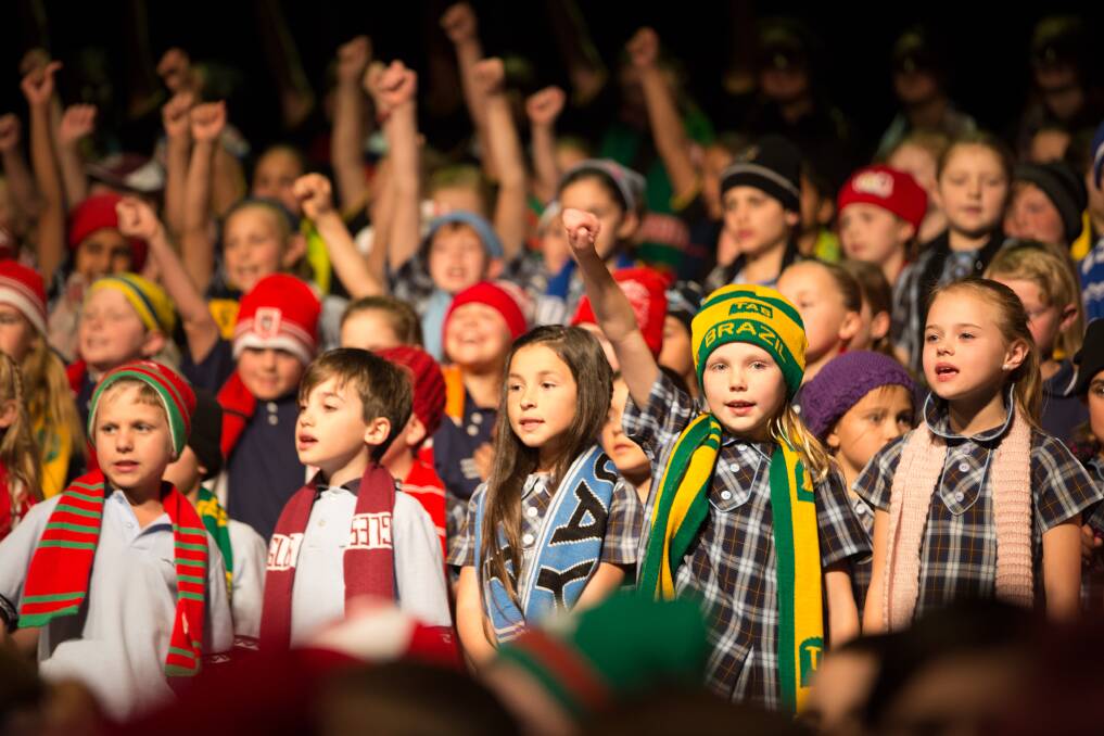 A mass multi-school choir decked out in the colours of their favourite sports teams sings That's My Team. Picture: SEASPRITE PHOTOGRAPHY