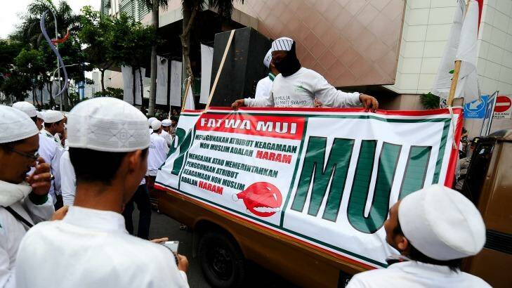 Islamic hardliners rally outside a shopping centre in Surabaya with a sign drawing attention to a fatwa issued by the Majelis Ulema Indonesia (MUI), an Islamic scholarly body, against Muslim staff wearing Christmas hats. Photo: Robertus Pudyanto