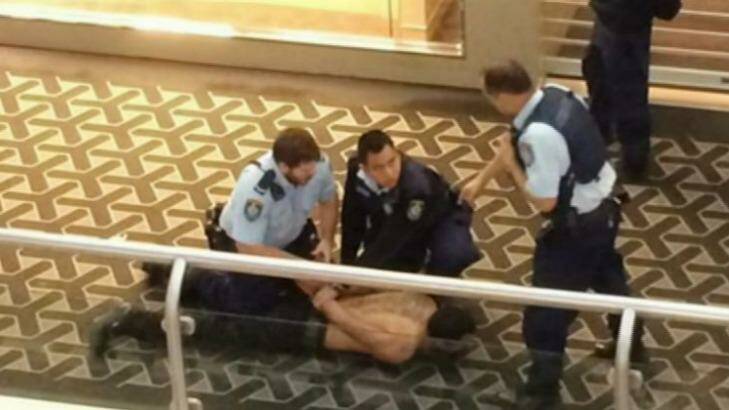 Restrained: Police subdue a man after the stabbing. Photo: Channel Nine