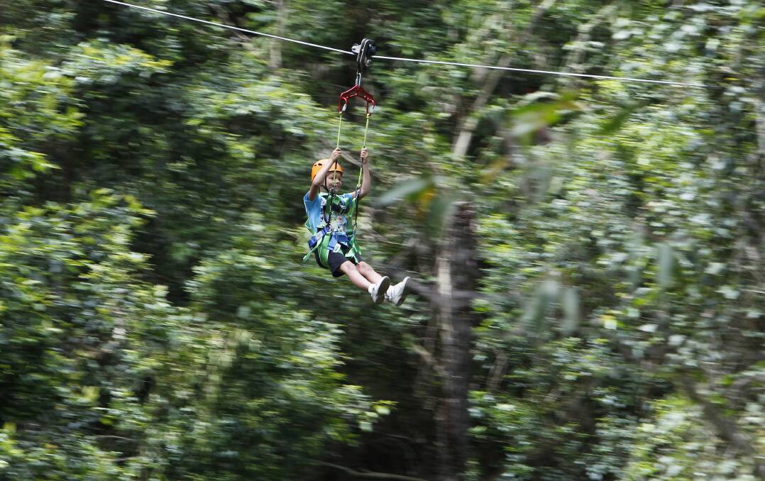 Tyler Davidson, 8, flies through the air between trees on the Illawarra escarpment. Picture: ANDY ZAKELI
