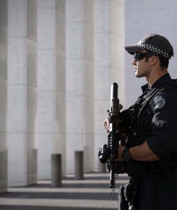An AFP officer armed with an SR-16 stands guard to the front of Parliament House in Canberra in October.  Photo: Andrew Meares