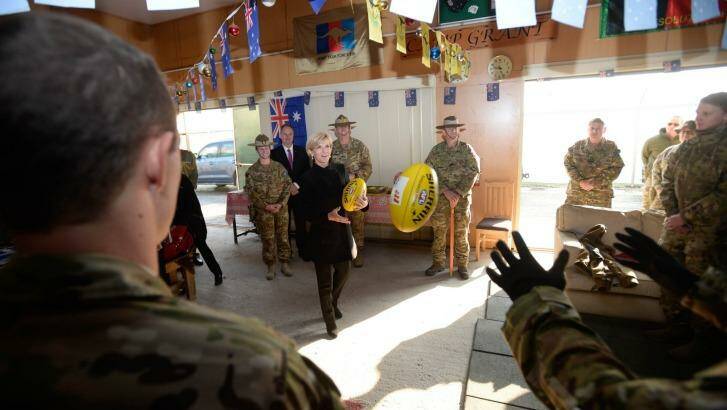 Julie Bishop plays football with Australian troops during her visit on Australia Day.  Photo: Justin McManus