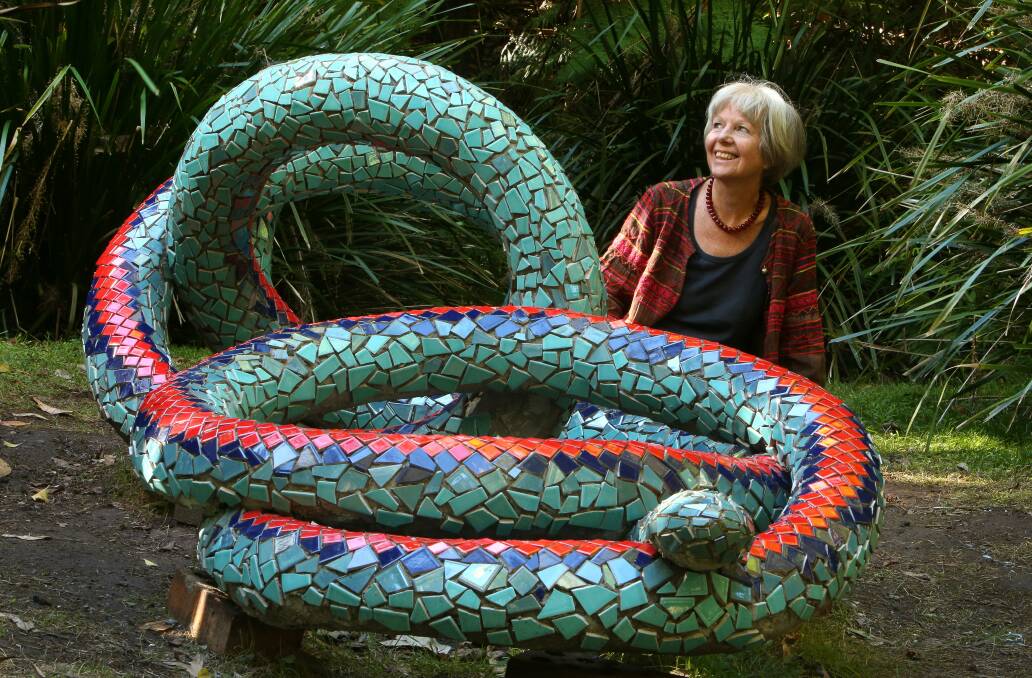 Gaby Porter with her nearly finished Rainbow Snake sculpture in the garden. Picture: KIRK GILMOUR