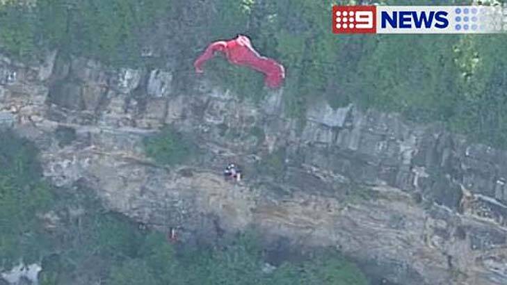 Dangling from a cliff: witnesses could hear the paraglider's screams. Photo: Screen grab, Nine News