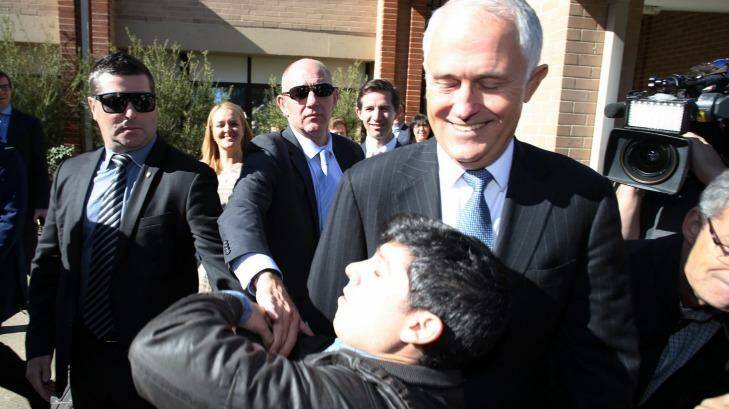 Chas Licciardello from The Chaser TV comedy show falls at the feet of Prime Minister Malcolm Turnbull as part of a trust stunt in western Sydney. Photo: Andrew Meares