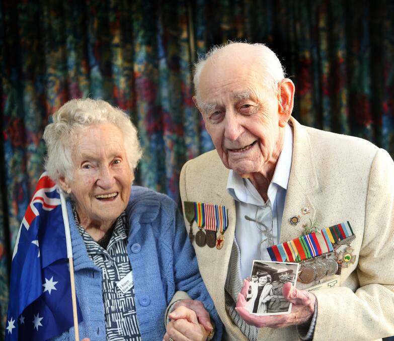 Paul Lavallee with his wife Doreen 95yrs old. Both now living at the Chesalon Nursing Home in Woonona. Paul is holding a photo of themselves on his return from the war in 1945 when they were engaged and married in 1946. Picture: KIRK GILMOUR