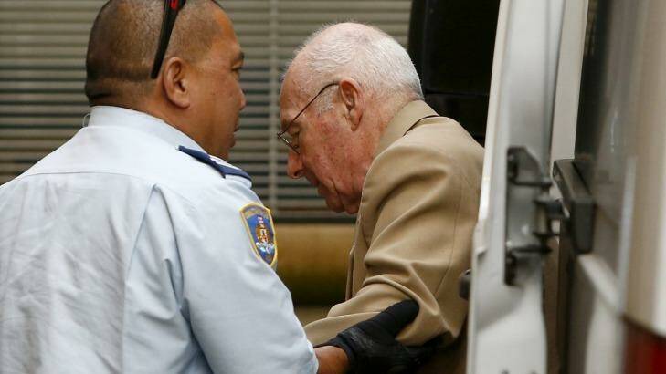 A correctional officer escorts Roger Rogerson to court for his murder trial last week.  Photo: Daniel Munoz