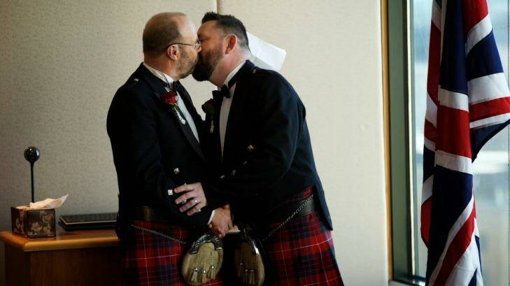 Gordon Stevenson and Peter Fraser embrace after exchanging rings at their wedding at the British consulate in Sydney on Friday. Photo: Wolter Peeters