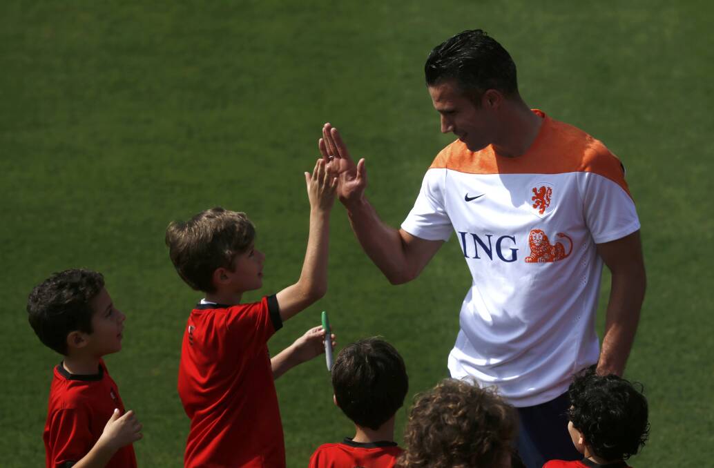 Robin van Persie greets children at a training session in Rio de Janeiro. Picture: REUTERS