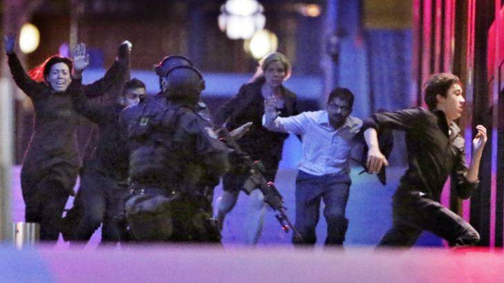 Hostages flee from the Lindt cafe. Photo: Andrew Meares