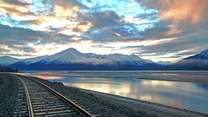 Train tracks and mountains are illuminated by the sunrise over Turnagain Arm in south central Alaska.  Photo: iStock