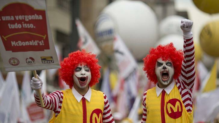 Two demonstrators dressed as Ronald McDonald take part in a protest for better wages and working conditions for McDonald's employees, in Sao Paulo, Brazil, Tuesday, Aug. 18, 2015. The protest gathered McDonald's workers, union representatives from 20 countries, and members of the Restaurant Workers Union. (AP Photo/Andre Penner) Photo: Andre Penner