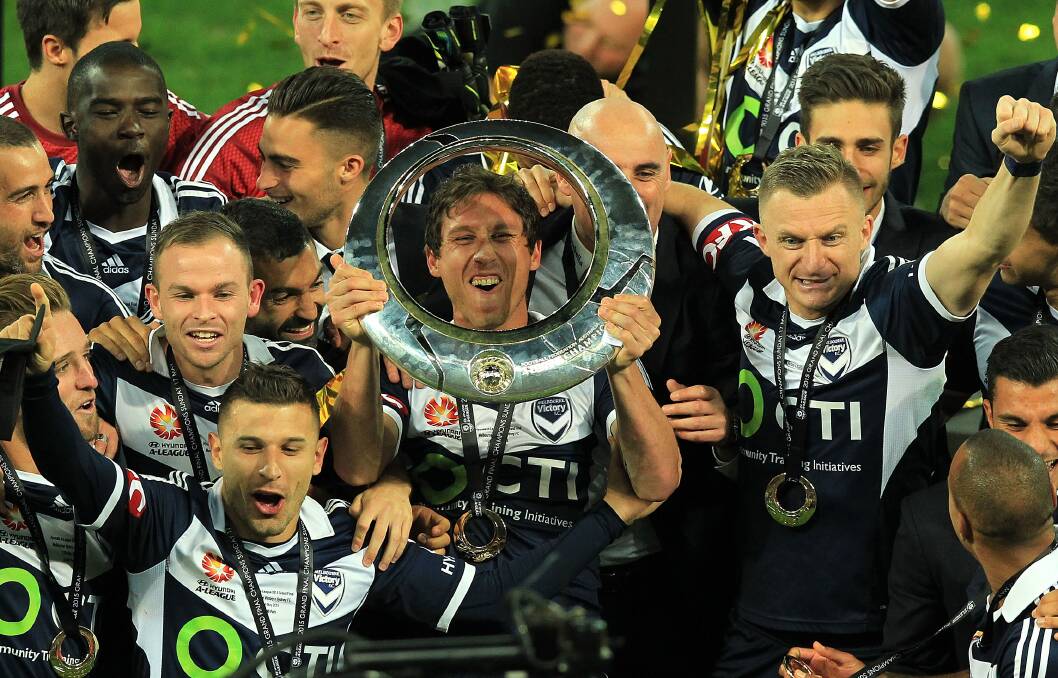MELBOURNE, AUSTRALIA - MAY 17:  Mark Milligan (#5) of Melbourne Victory holds the trophy as he celebrates with his teamates following victory in the 2015 A-League Grand Final match between the Melbourne Victory and Sydney FC at AAMI Parkon May 17, 2015 in Melbourne, Australia.  (Photo by Graham Denholm/Getty Images)