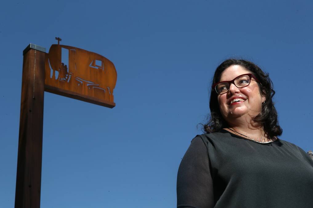 Nerine Martini with one of the Dwellings artworks – a silhouette of migrant Les Kirchmajer’s first home in Australia – a caravan in Oak Flats. Picture: KIRK GILMOUR