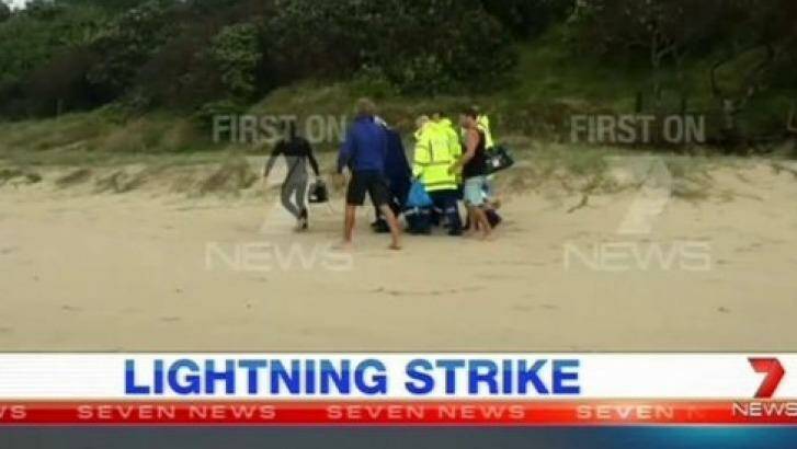 A surfer is carried from Suffolk Park beach after he was struck by lightning on Sunday morning. Photo: Channel 7