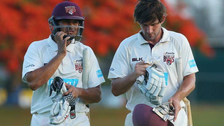 In thought...Queensland players Usman Khawaja and Joe Burns of the bulls leave the field at the end of play. Photo: Chris Hyde