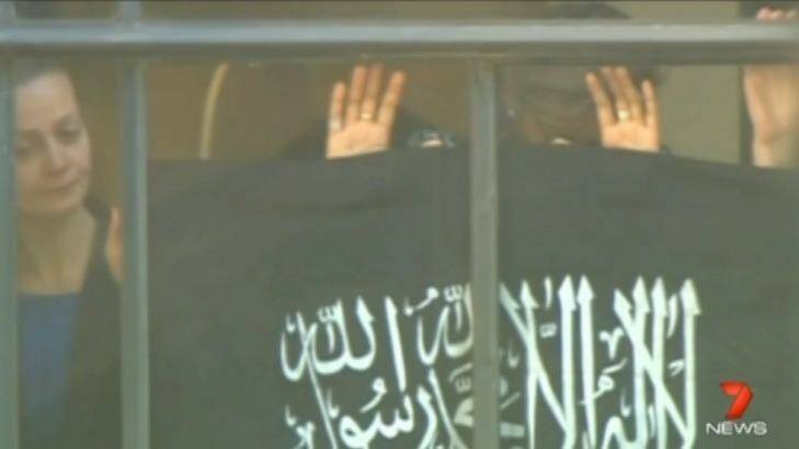 "One of the hardest things to see": Hostages hold the flag against the Lindt Cafe window. Photo: Channel Seven