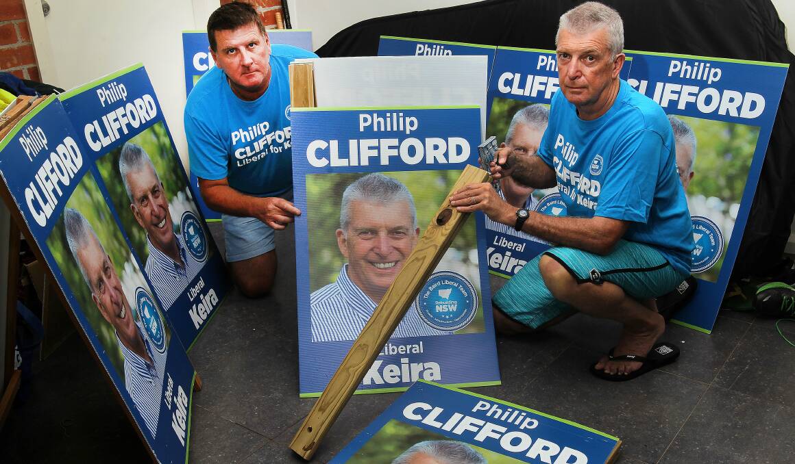 Soapbox: Campaign assistant Greg Jones and Liberal candidate for Keira Philip Clifford with one of his signs he claims was damaged after a run-in with the organiser of the Foragers Markets on Sunday morning. Picture: GREG TOTMAN