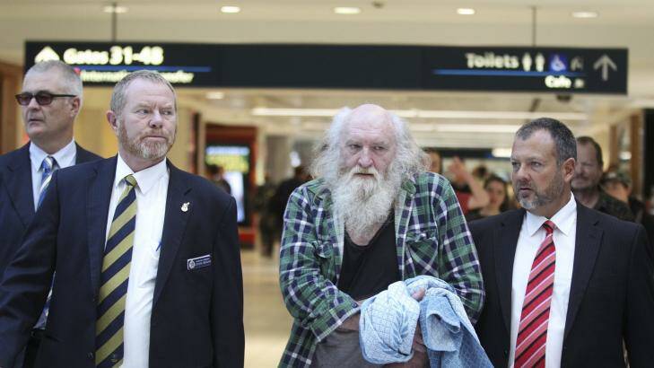 Arrest: Colin Michael Newey is escorted by police on Thursday at Sydney Airport. Photo: Janie Barrett
