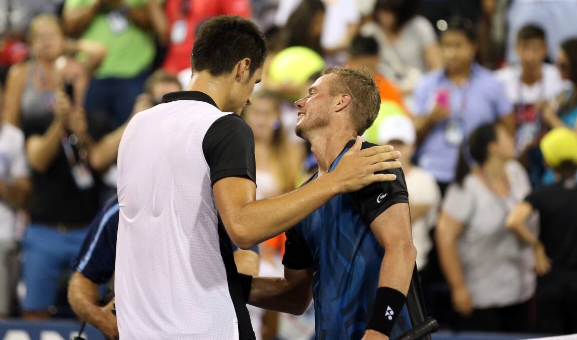 Bernard Tomic consoles Lleyton Hewitt after their five-set epic. Picture: GETTY IMAGES