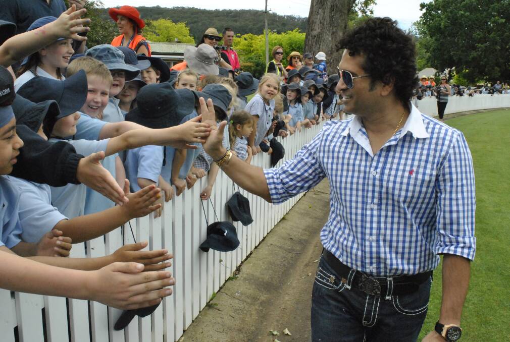 Meeting the fans: Sachin Tendulkar high-fives his adoring followers at Bradman Oval, Bowral, on Thursday morning. Picture: JOSH BARTLETT