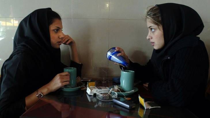 Time out: Girls chat over a cup of tea and a cigarette in a cafe.