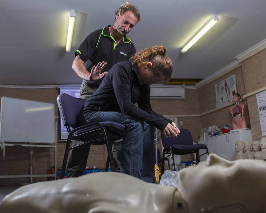 Wollongong paramedic Mark McCarthy uses patient Rebecca McCarthy to show the proper way to treat someone potentially choking. Picture: CHRISTOPHER CHAN