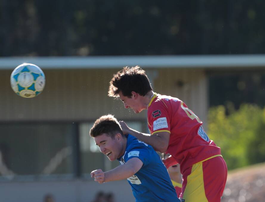Bulli's Cameron Littler, left, and Wollongong United's Scott Burleigh at Macedonia Park on Saturday in a clash that left Bulli collecting the kudos and the points in a decisive 3-1 win. Picture: ADAM McLEAN