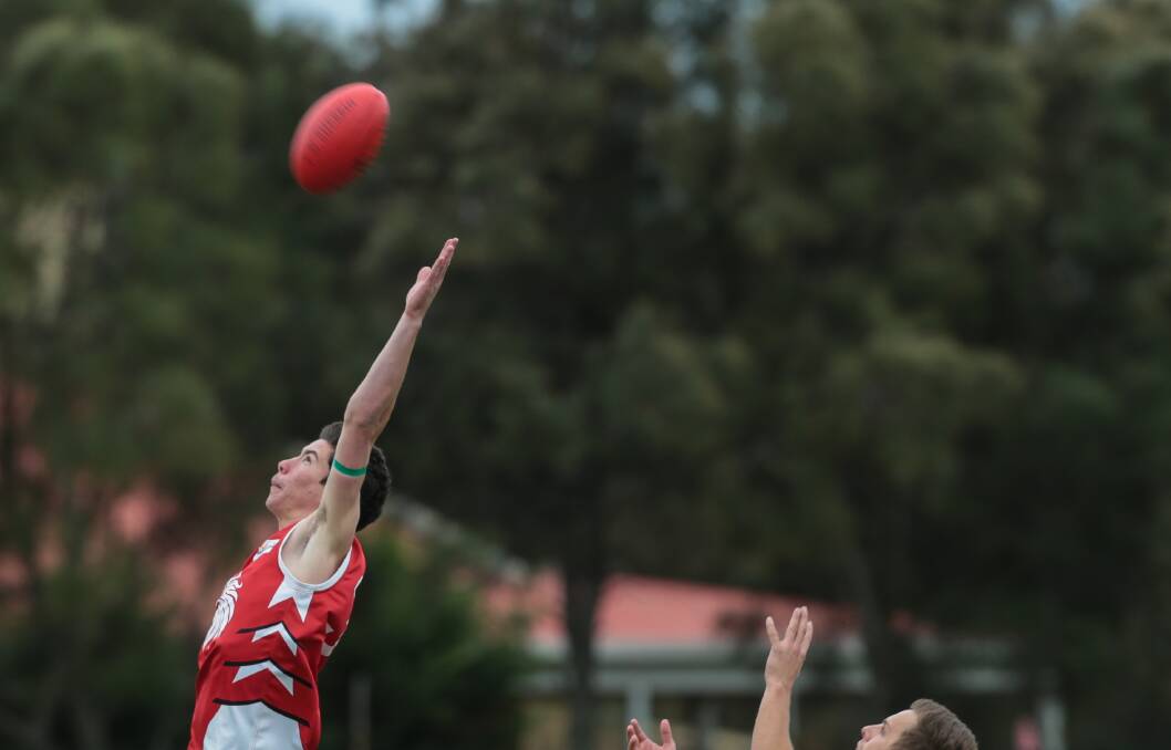 Teenage Lions player Braydon Greenwood leaps for the ball against Macquarie University at North Dalton Park in May. Picture: ADAM McLEAN