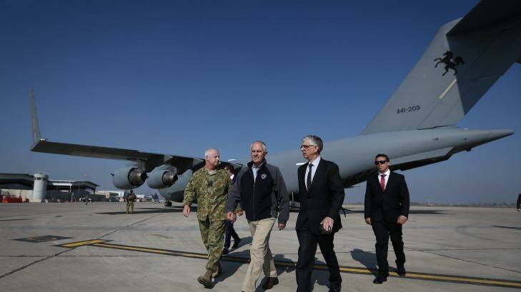 Prime Minister Malcolm Turnbull, centre, exits a C-17 Globemaster after arriving in Baghdad, Iraq, during a visit to meet with troops involved in Operation Okra, on Saturday.  Photo: Alex Ellinghausen