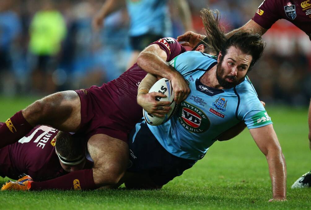 NSW's workaholic front-rower Aaron Woods is wrapped up by Queensland skipper Cameron Smith in Wednesday night's opening State of Origin clash in Sydney.Picture: GETTY IMAGES