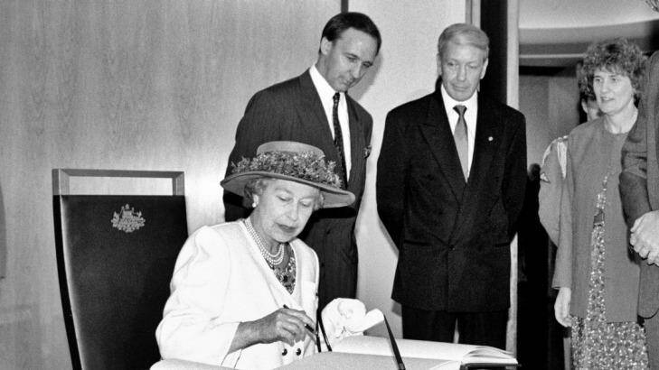 The Queen signs the visitors' book at Parliament House, while prime minister Paul Keating and Parliament House officials look on in February 1992. Photo: National Archives of Australia