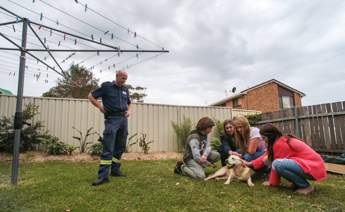 Rapt: Fire Rescue NSW's Tim Garrett looks on as retiring accelerant detection dog Sheba meets her new family Sam, Giorgia, Bridie and Bron Eastment in Kiama Downs. Picture: ADAM McLEAN
