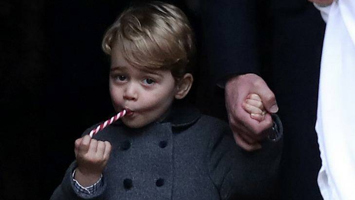 Cute: Prince George eats a sweet treat. Photo: AP/Andrew Matthews