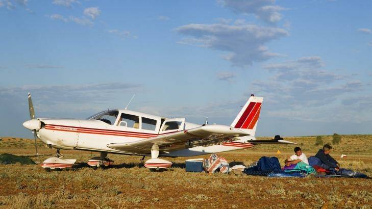 People camping next to a plane on a bush airstrip during the annual Birdsville Races.  Photo: Andrew Watson