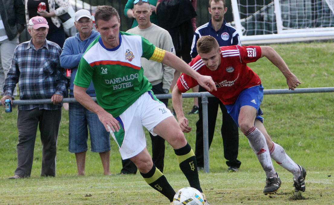 Dapto's defender and former Socceroo Alvin Ceccoli is chased by Albion Park's Mark Every. Picture: GREG TOTMAN
