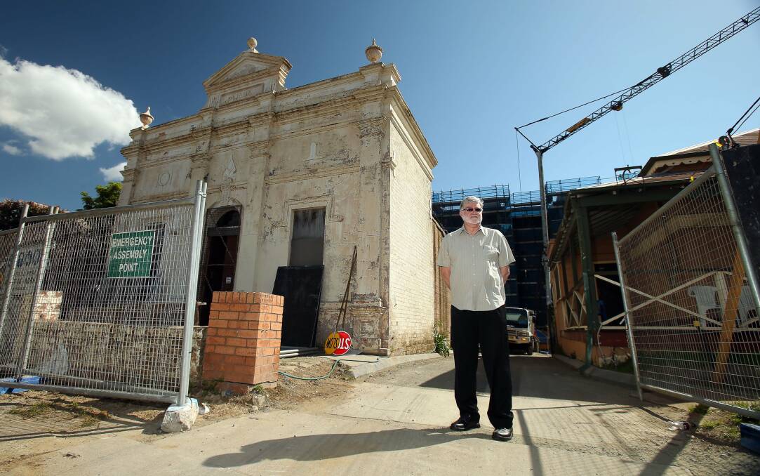 Glenn Mitchell outside the old Masonic Hall and a new apartment block being built behind it on Smith Street, Wollongong. Picture: KIRK GILMOUR