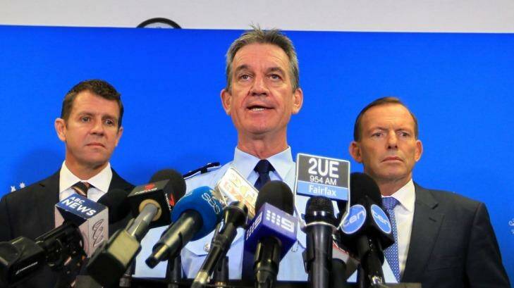 NSW Police Commissioner Andrew Scipione (centre), flanked by NSW Premier Mike Baird and Prime Minister Tony Abbott, has been criticised for failing to resolve the scandal.  Photo: James Alcock