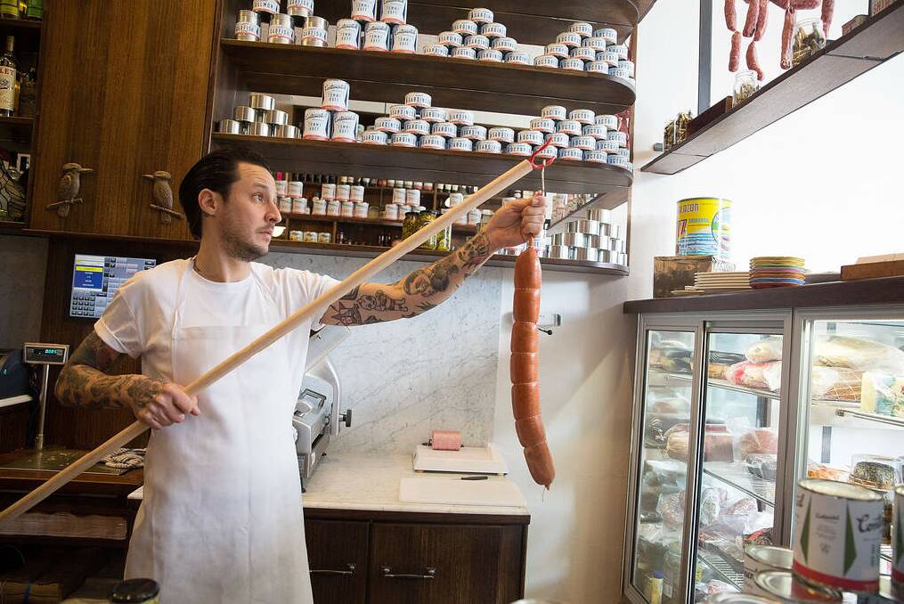 Elvis Abrahanowicz hangs sausages in his new deli. Photo: Michele Mossop
