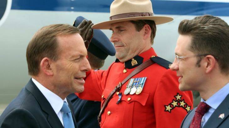 Tony Abbott, left, is greeted by Pierre Poilievre, a Canadian minister, at Ottawa airport. Photo: Andrew Meares
