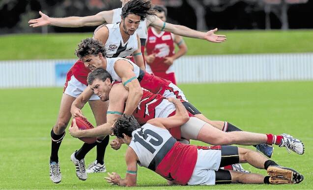 Illawarra Lions player Stewart Boyd leaps to shut down a Macquarie University raid. Picture: ADAM McLEAN