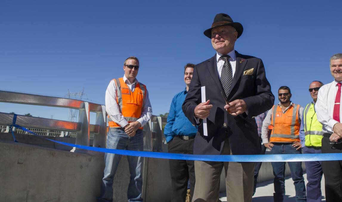 Opening: Gordon Bradbery prepares to cut the ribbon to officially open the road and bridge works along Shone Avenue. Picture: CHRISTOPHER CHAN