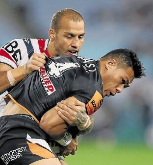 SYDNEY, AUSTRALIA - JULY 24:  Blake Ferguson of the Roosters tackles Tim Simona of the Wests Tigers during the round 20 NRL match between the Wests Tigers and the Sydney Roosters at ANZ Stadium on July 24, 2015 in Sydney, Australia.  (Photo by Mark Kolbe/Getty Images)